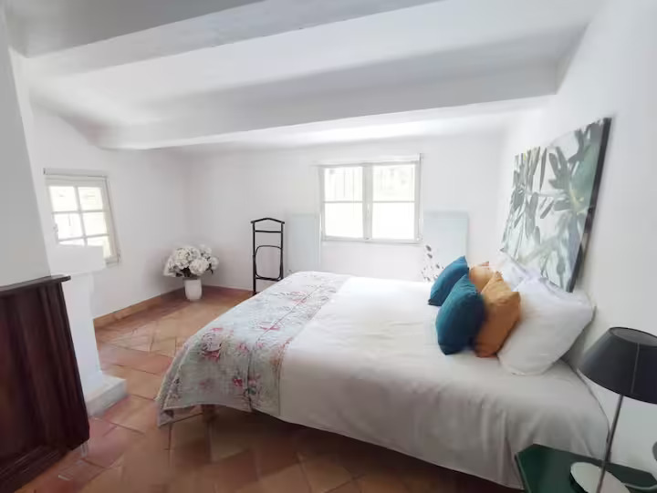 Bright bedroom with cozy bed and decorative pillows.
