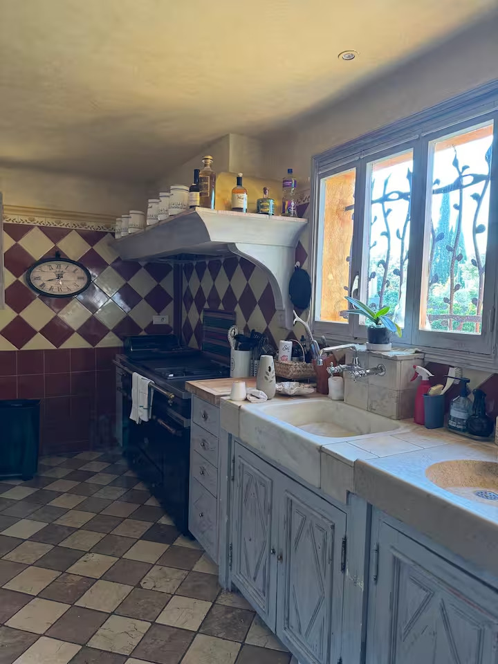 Cuisine traditionnelle avec carreaux et cuisinière.