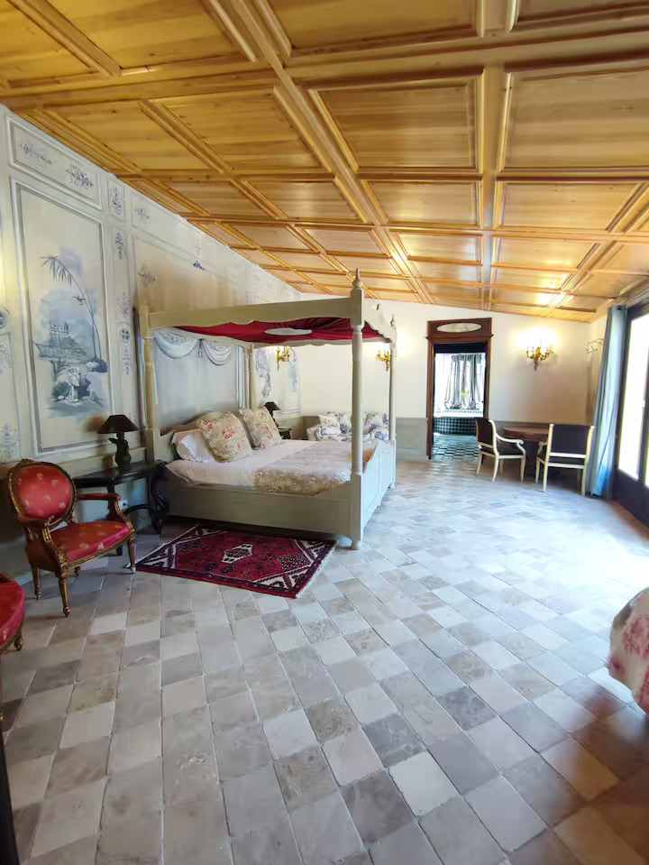 Chambre avec lit à baldaquin et décor classique.