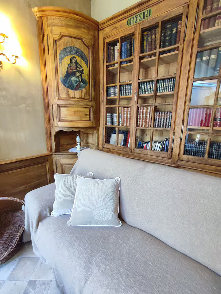 Salon ancien avec bibliothèque en bois.