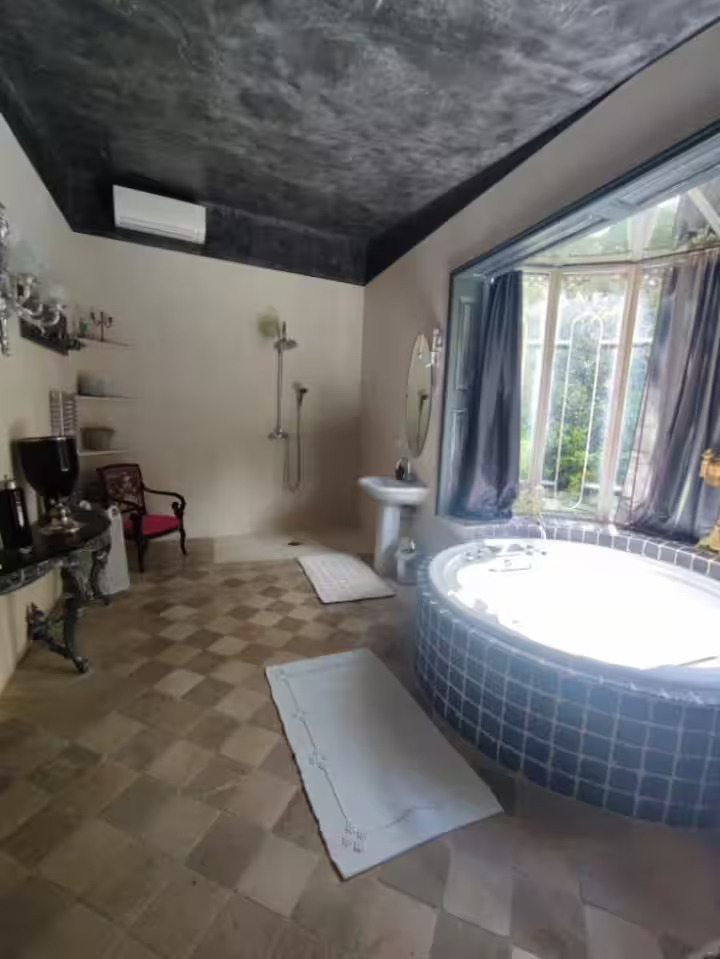 Salle de bain avec jacuzzi et fenêtre lumineuse.