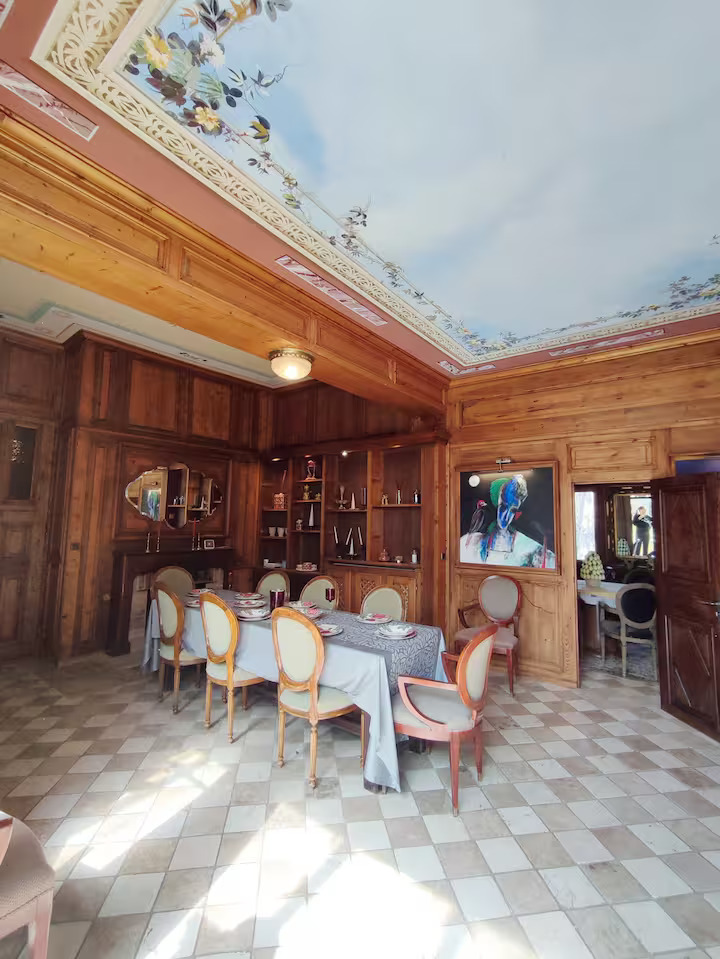 Salle à manger avec plafond orné floral.